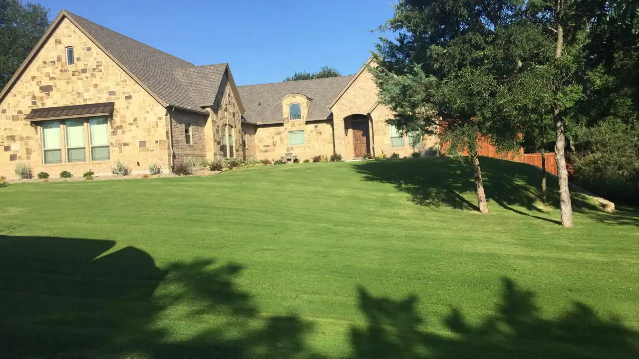 A stone home in the Fort Worth area with mature trees and a broad front lawn suited to landscape lighting